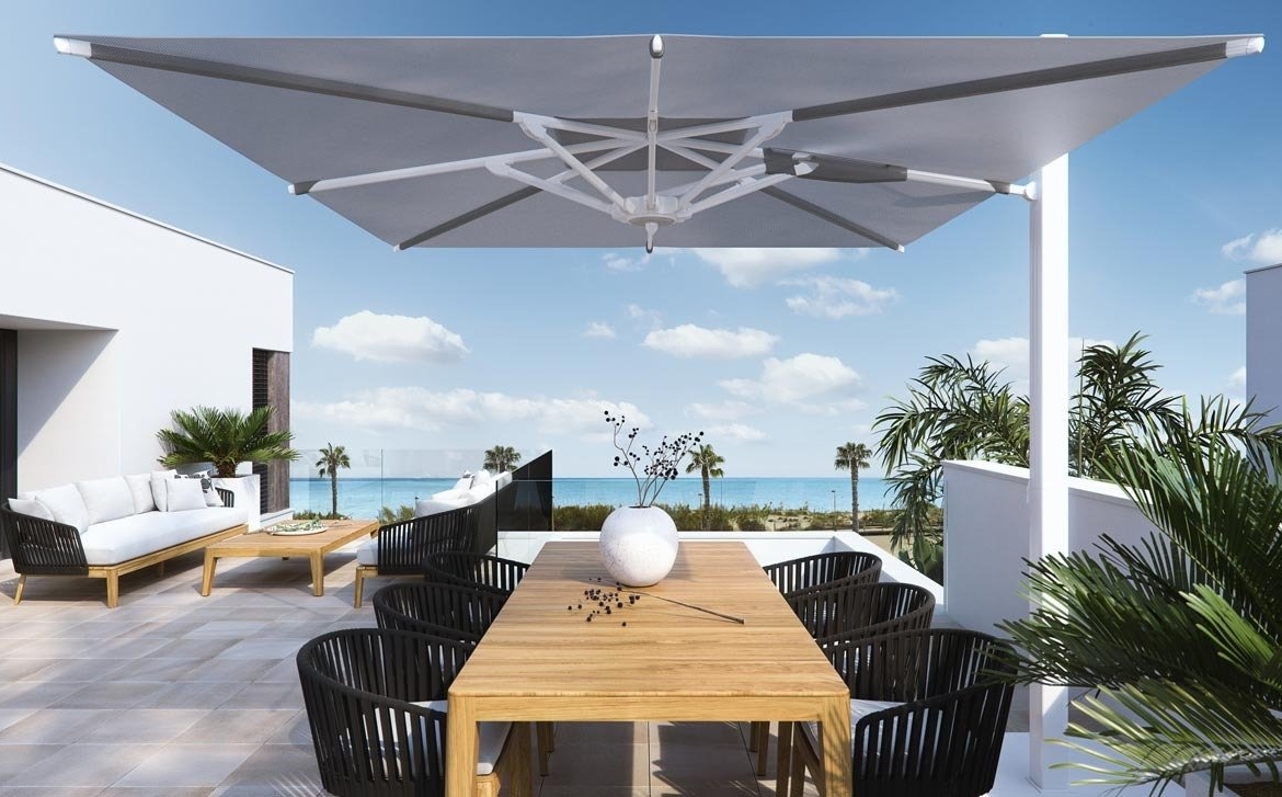 Sun-drenched terrace with modern dining area and lounge overlooking panoramic sea views at new build villas in Torre de la Horadada