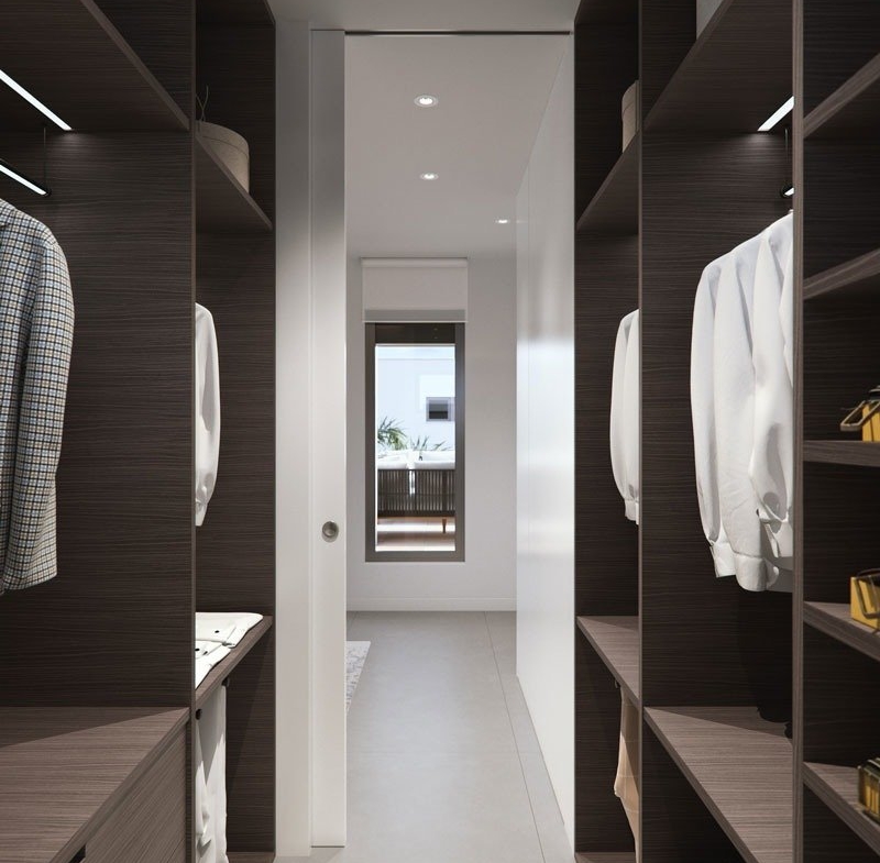 Elegant walk-in closet with dark wood shelving and natural light in new build villas in Torre de la Horadada