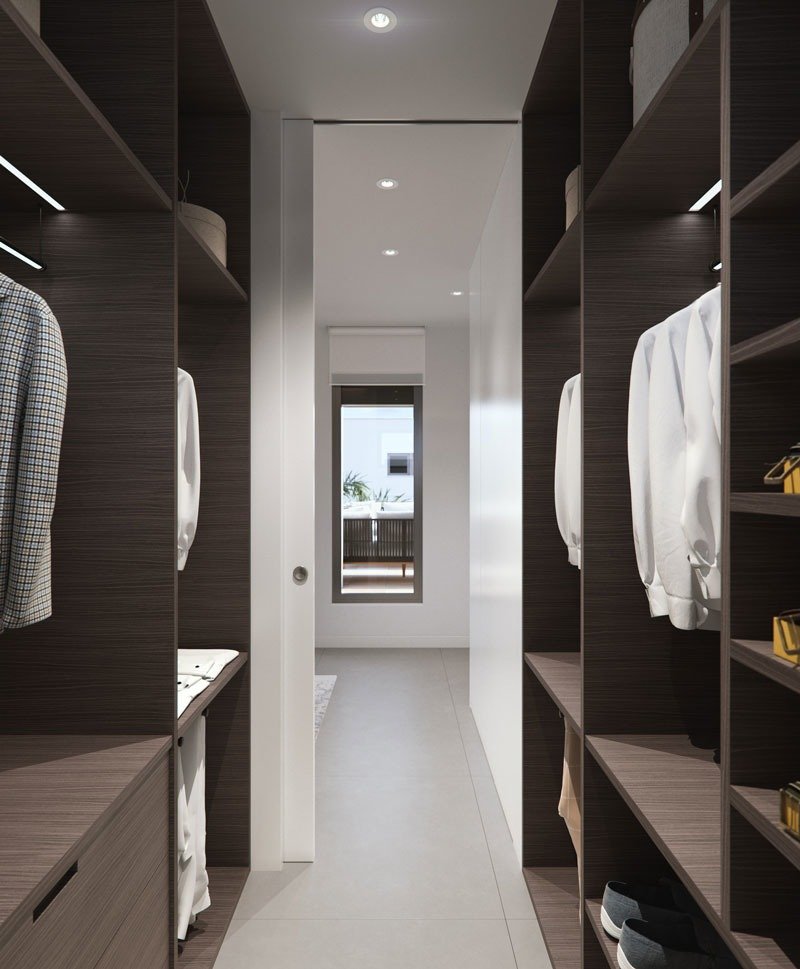 Elegant walk-in closet with dark wood shelving and natural light in new build villas in Torre de la Horadada