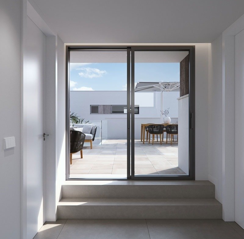 Bright modern hallway leading to a sun-drenched terrace with elegant outdoor seating in new build villas in Torre de la Horadada