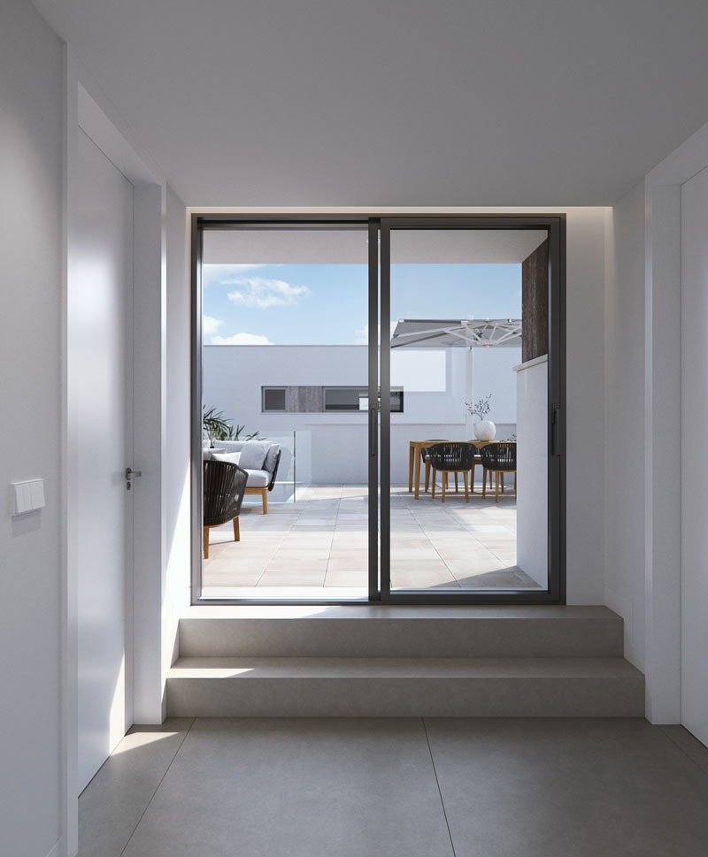 Bright modern hallway leading to a sun-drenched terrace with elegant outdoor seating in new build villas in Torre de la Horadada