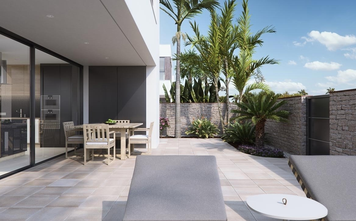 Sun-drenched terrace with modern outdoor dining and loungers in new build villas in Torre de la Horadada