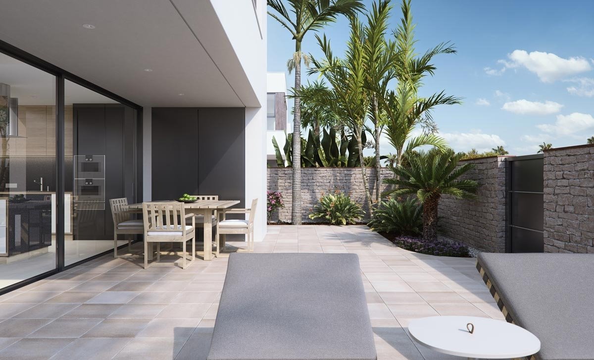 Sun-drenched terrace with modern outdoor dining and loungers in new build villas in Torre de la Horadada