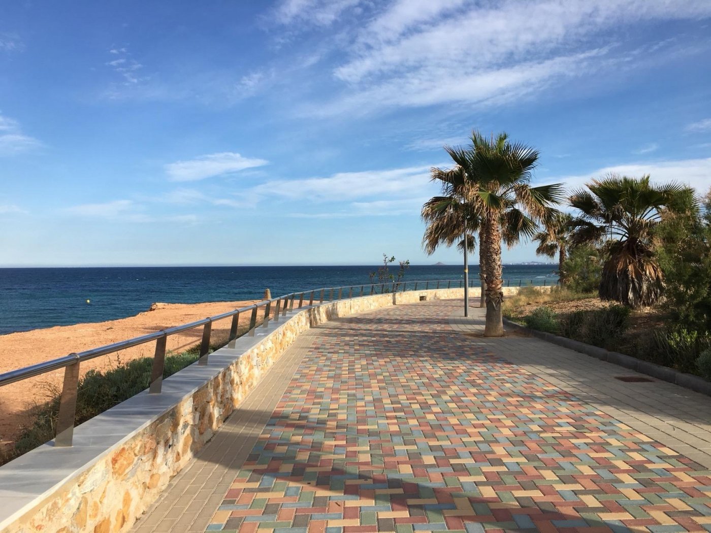 Sun-drenched coastal promenade with palm trees and sea views near new build villas in Torre de la Horadada