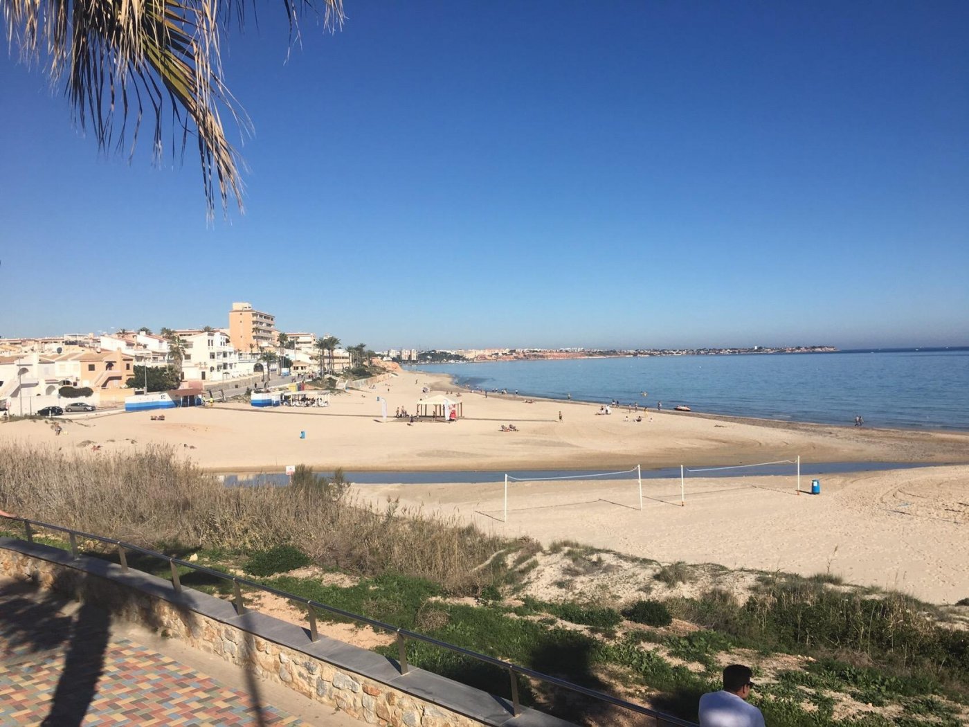 Panoramic sun-drenched beach view from new build villas in Torre de la Horadada, showcasing serene coastline and clear blue sky