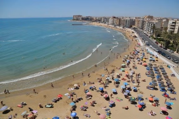 NEW-BUILD-VILLAS-IN-TORREVIEJA-14 Vibrant sunlit beach near Aguas Nuevas, Torrevieja, showcasing a lively coastal lifestyle perfect for the modern 3-bedroom villa buyer.