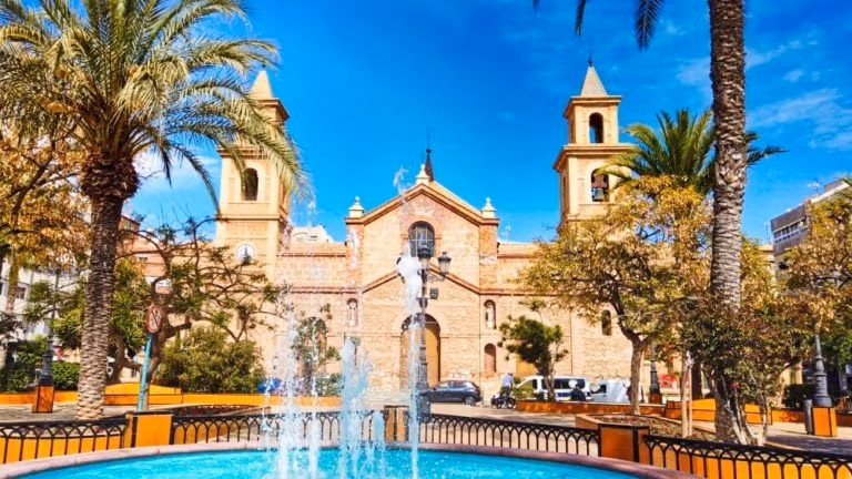 NEW-BUILD-VILLAS-IN-TORREVIEJA-15 Sunlit historic plaza framed by palm trees near modern new build 3 bedroom villa with private pool in Aguas Nuevas, Torrevieja