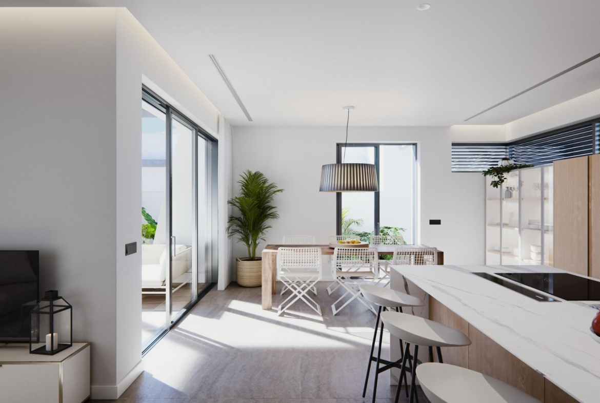 Sun-drenched open-plan kitchen and dining area in a modern newly built villa on a floor with large windows and sleek finishes.