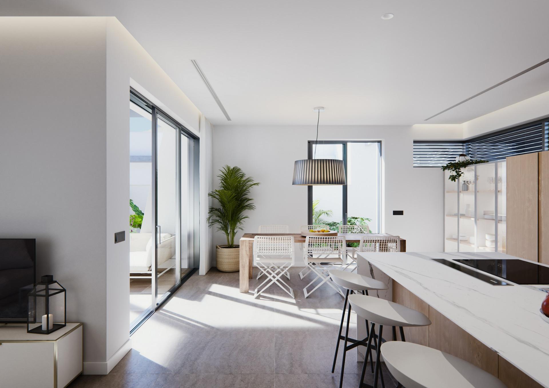 Sun-drenched open-plan kitchen and dining area in a modern newly built villa on a floor with large windows and sleek finishes.