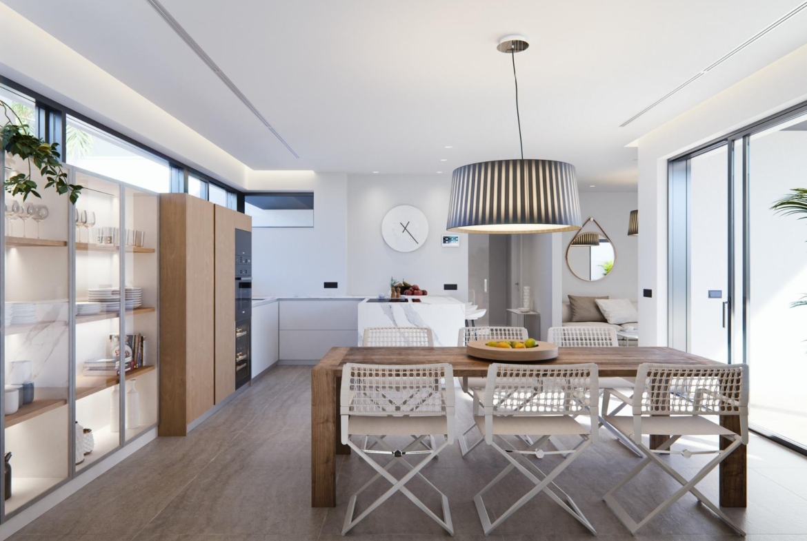 Bright modern dining area and open-plan kitchen with sleek cabinetry in a new built villa on a floor.