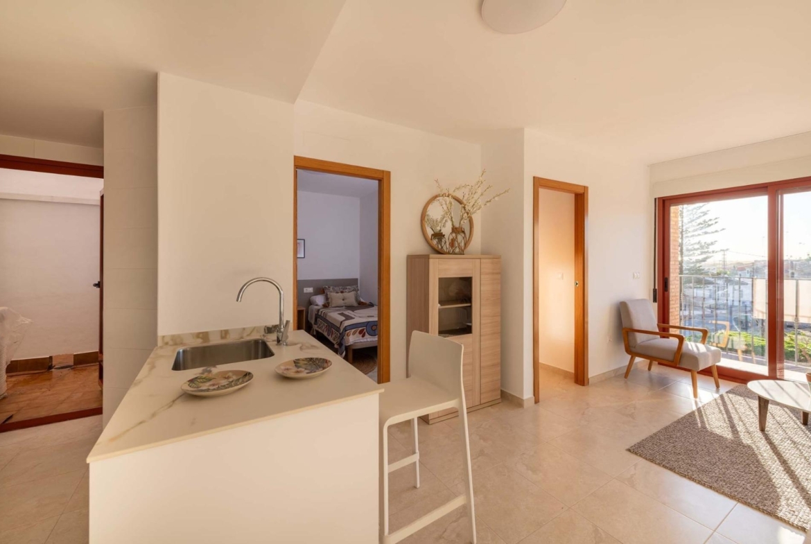 Bright open-plan living area and modern kitchen of affordable new build 1-bedroom apartment in Avileses, Murcia with balcony views.