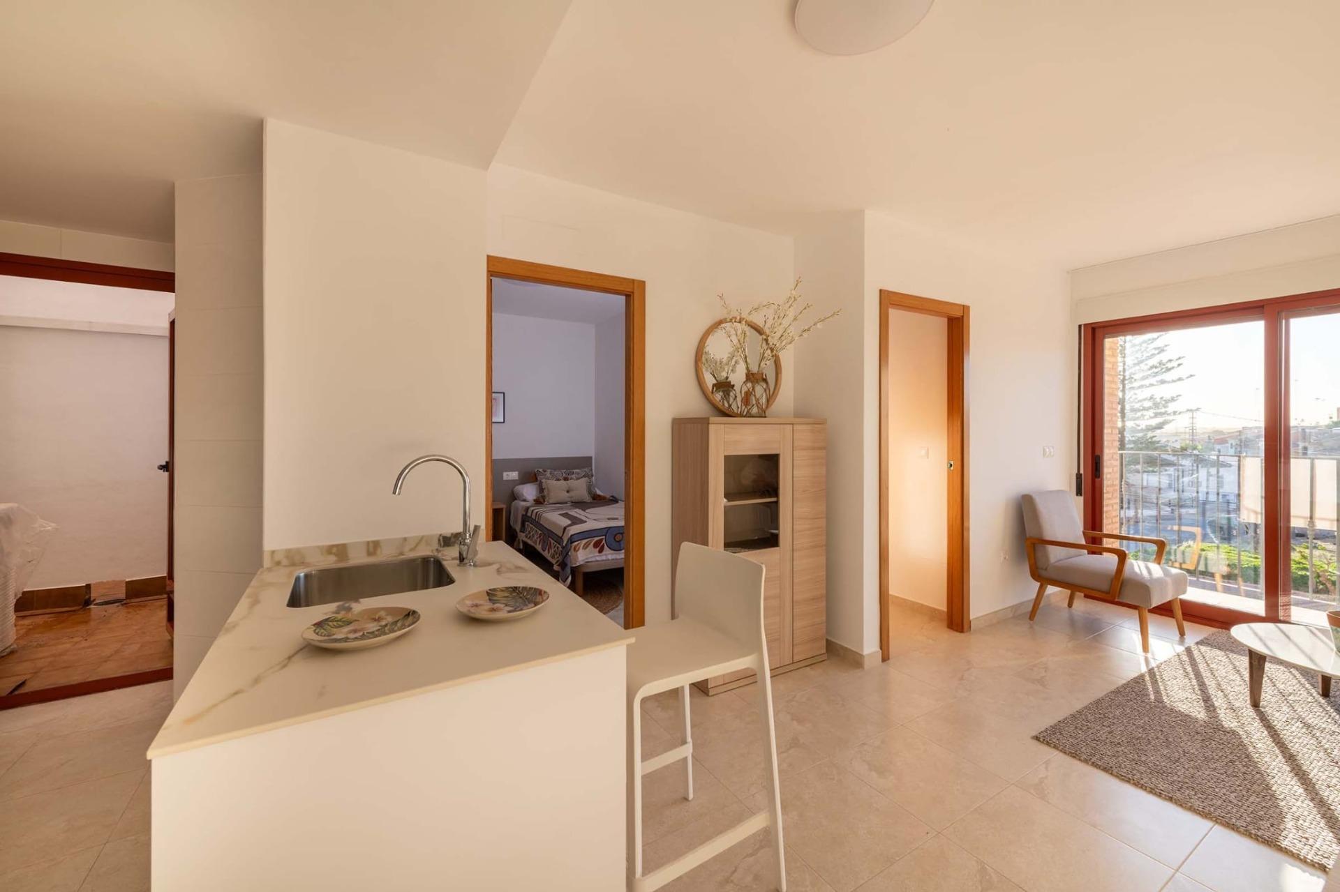 Bright open-plan living area and modern kitchen of affordable new build 1-bedroom apartment in Avileses, Murcia with balcony views.