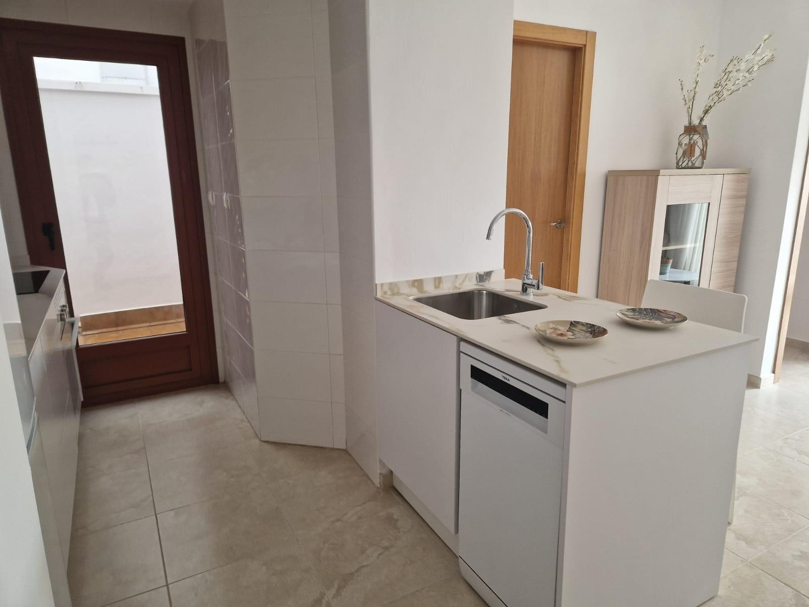Bright modern kitchen with sleek white cabinetry in an affordable new build studio apartment in Avileses, Murcia.