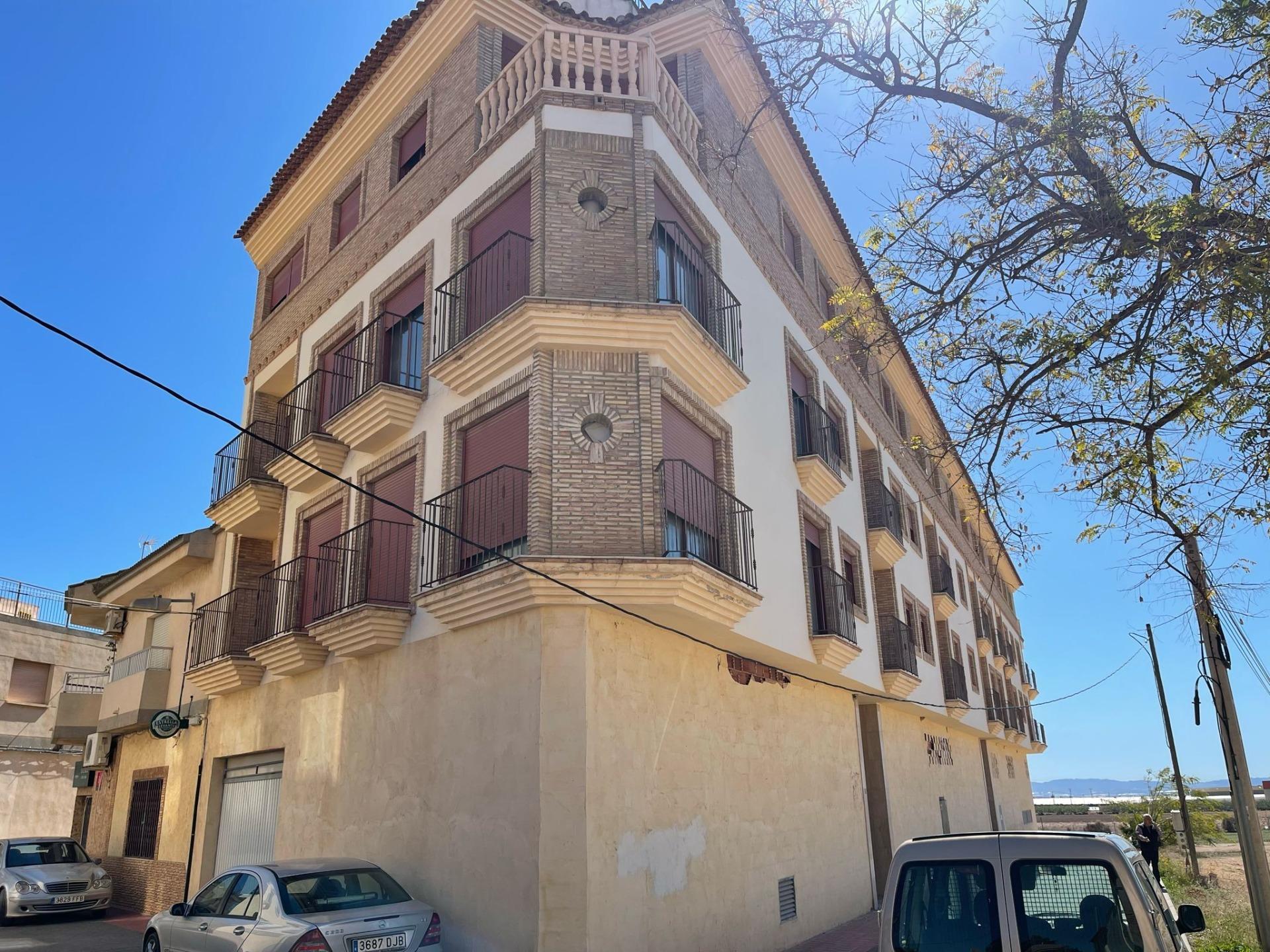 Modern exterior of a charming studio apartment building in Avileses, Murcia, with elegant balconies and bright façade under clear blue sky.