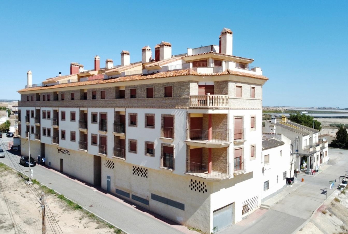 Modern new build 1-bedroom apartment building with sunlit communal pool, nestled in the serene outskirts of Avileses, Murcia.