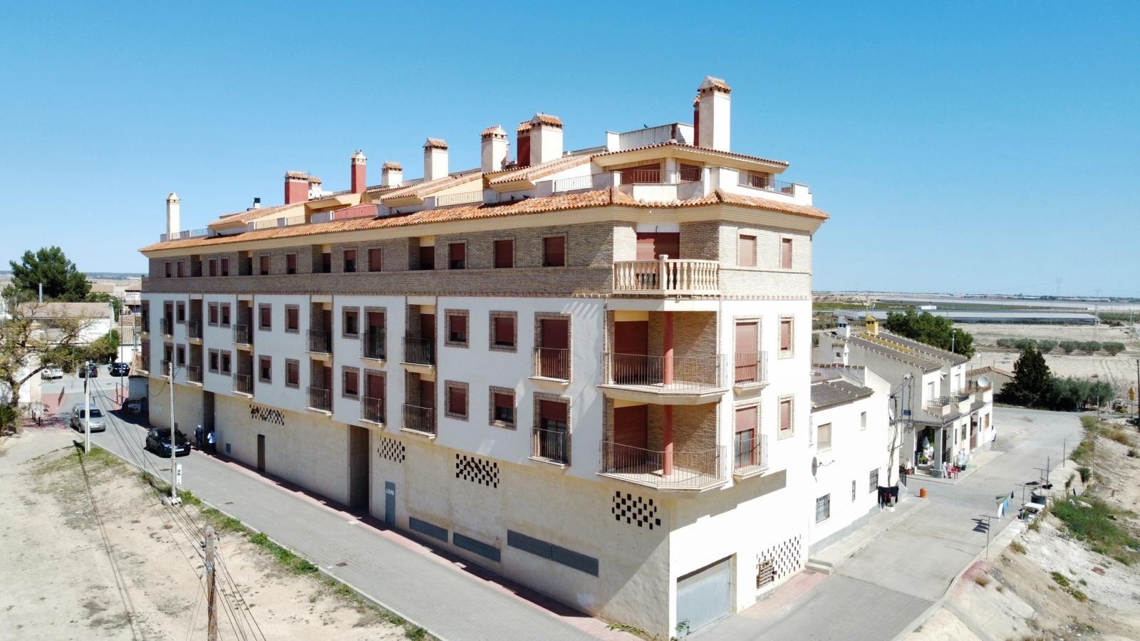 Modern new build 1-bedroom apartment building with sunlit communal pool, nestled in the serene outskirts of Avileses, Murcia.