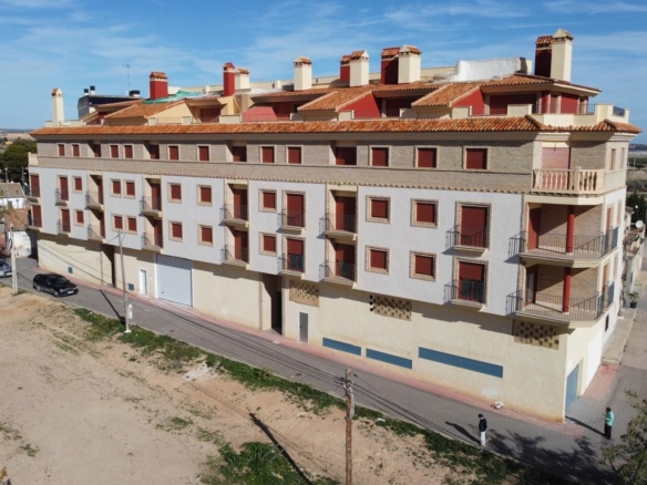 Modern affordable new build 1 bedroom apartment complex with terracotta roofs in sunlit Avileses, Murcia neighborhood.
