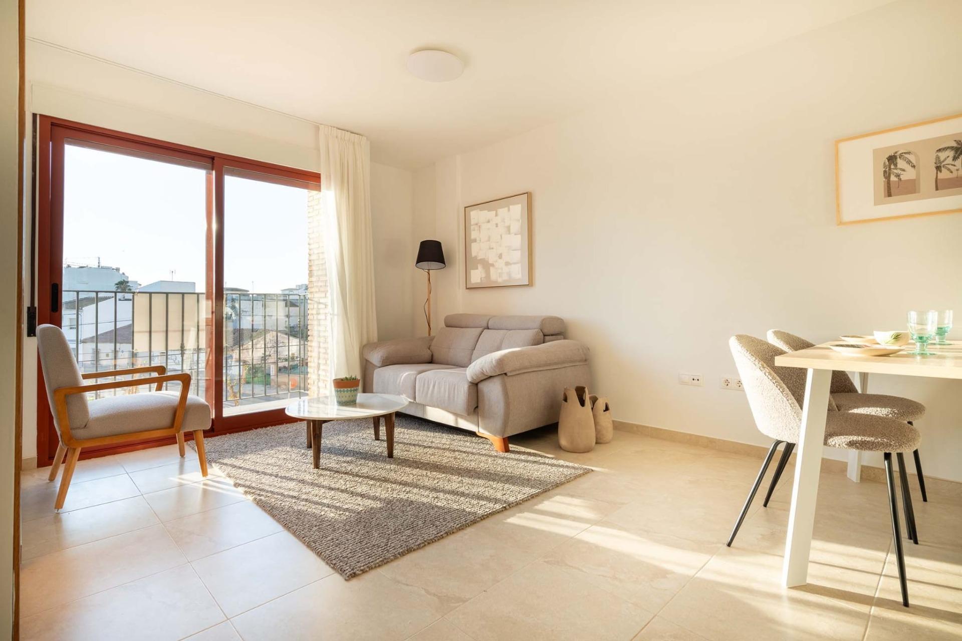 Bright, modern 1-bedroom apartment living area in Avileses, Murcia with sunlit open-plan design and balcony overlooking the neighborhood.