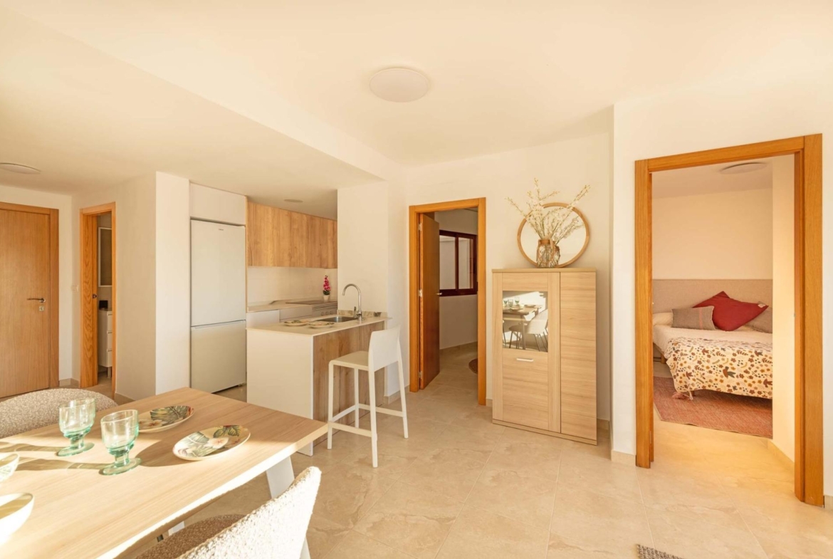 Bright modern kitchen and dining area with natural wood finishes in affordable new build studio apartment in Avileses, Murcia.