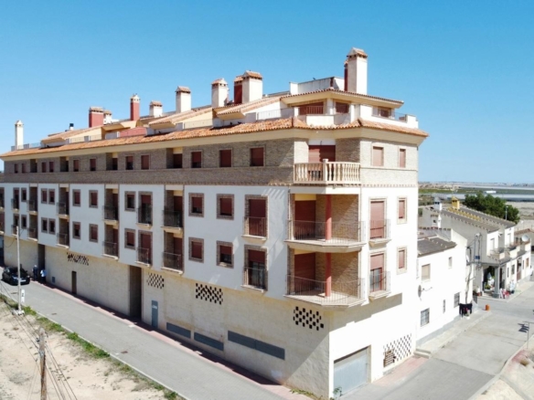 Bright and modern new build studio apartment complex with communal pool under clear blue skies in Avileses, Murcia.