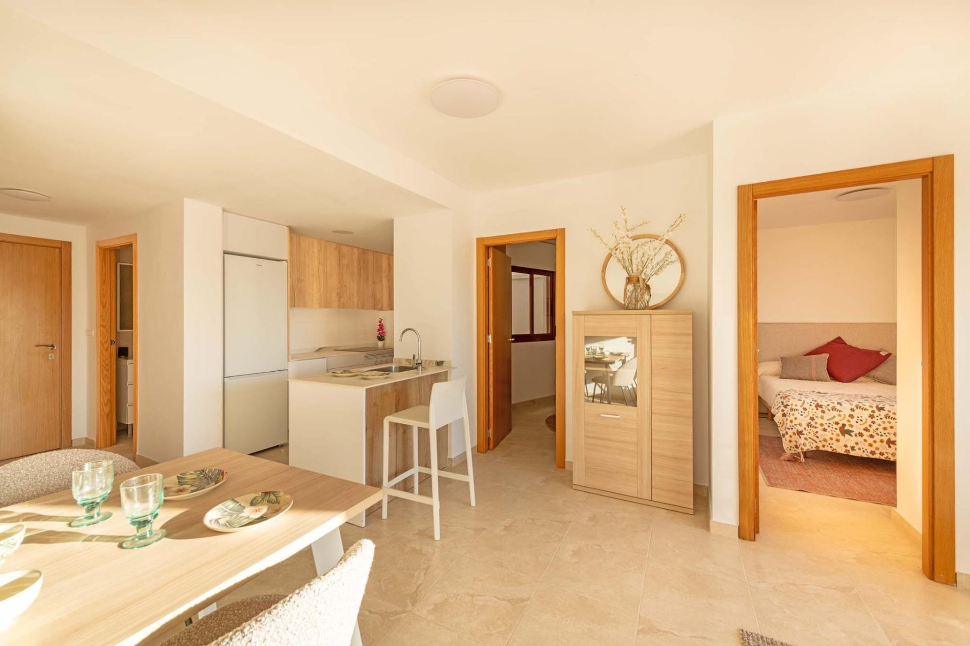 Bright modern 1-bedroom apartment interior with open-plan kitchen and dining area in affordable Avileses, Murcia new build.