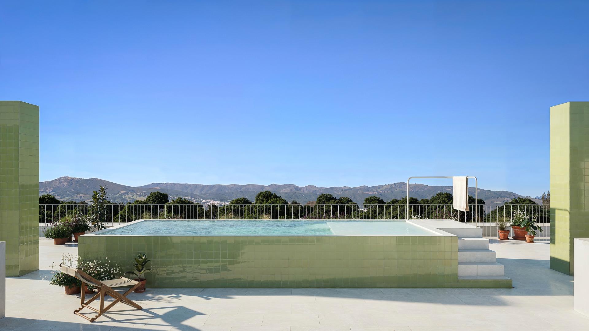 Spacious modern infinity pool with open panoramic mountain views at a luxury 3 bedroom apartment in Jacarilla