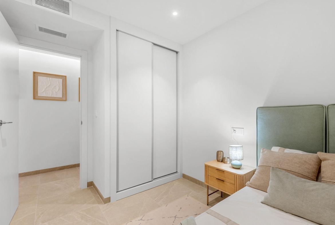 Bright modern bedroom with sleek built-in wardrobes in a luxury 3-bedroom apartment in Jacarilla with open views.