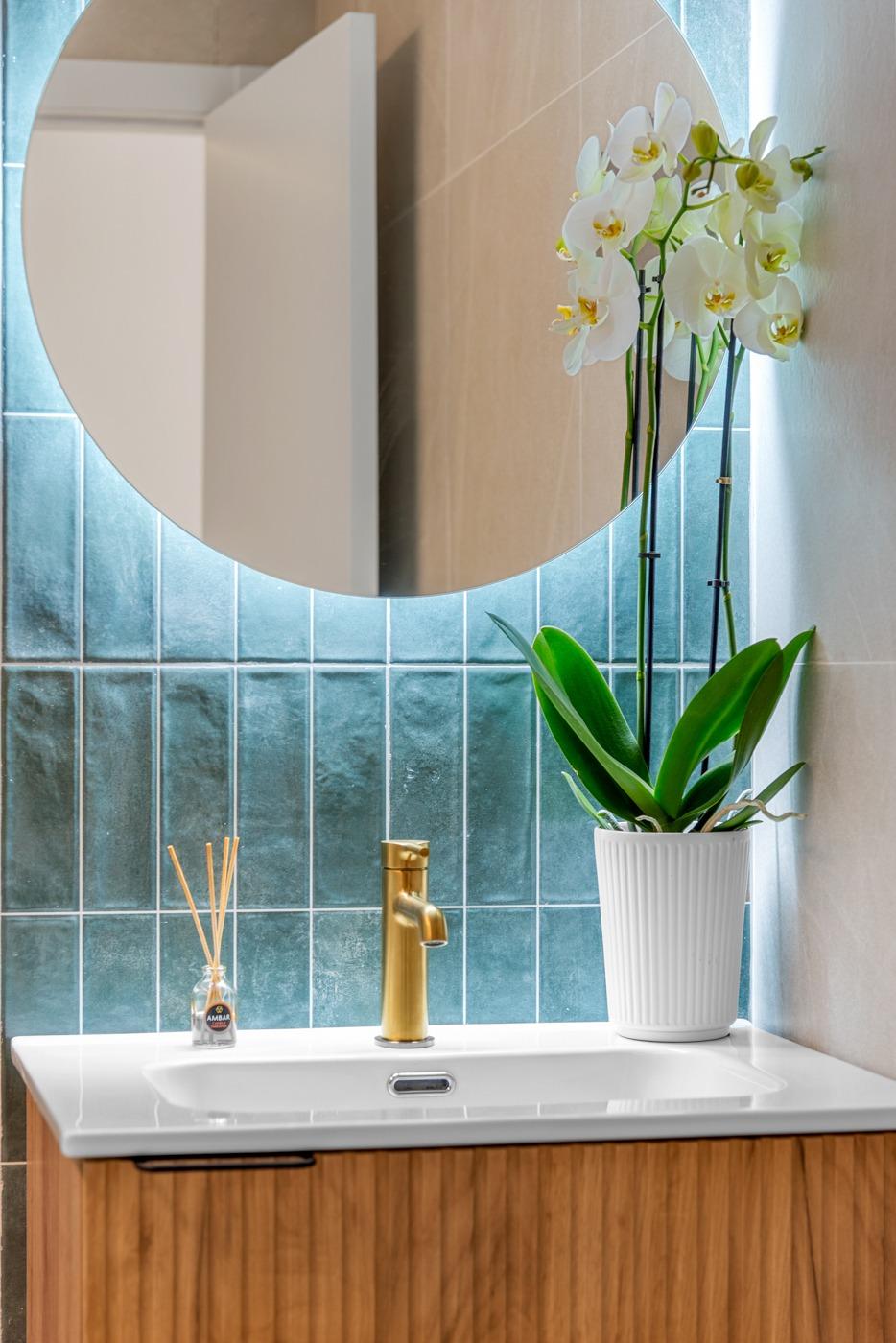Modern bathroom sink with elegant gold faucet and decorative orchid in spacious 3 bedroom ground floor apartment, Jacarilla.