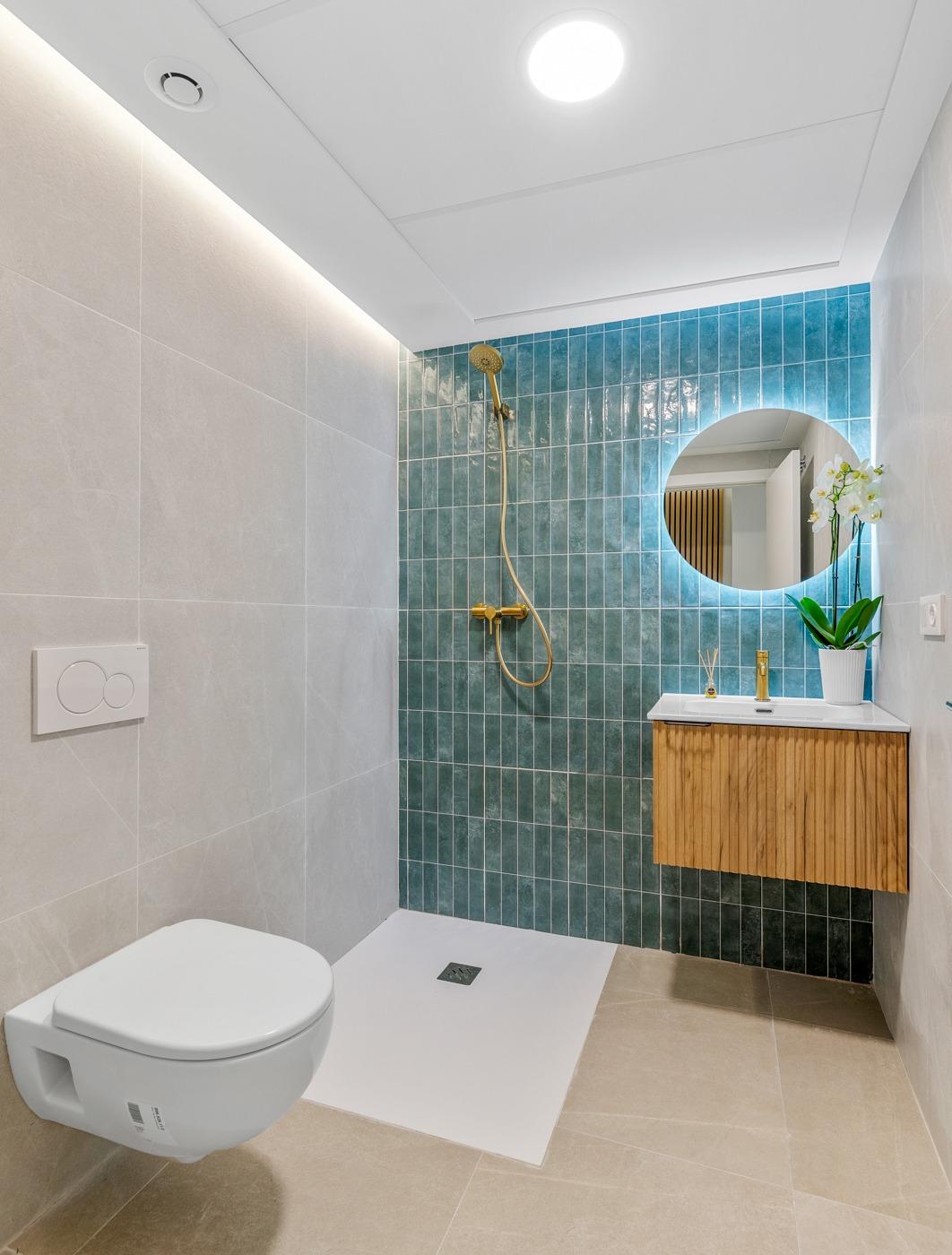 Bright modern bathroom with sleek floating vanity and gold fixtures in a new build 3 bedroom apartment in Jacarilla