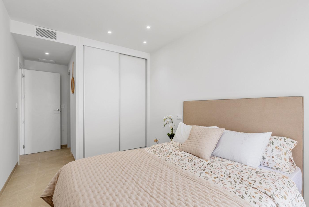 Bright and elegant bedroom with plush bedding in a new build 3-bedroom penthouse with terrace and open views in Jacarilla.