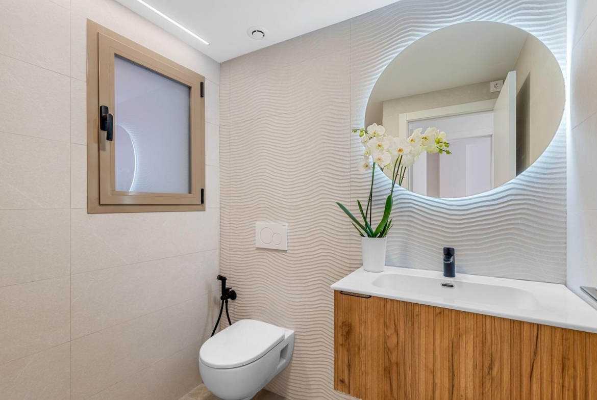 Modern, elegant bathroom with textured walls and wooden vanity in new build 3-bedroom penthouse with terrace in Jacarilla.