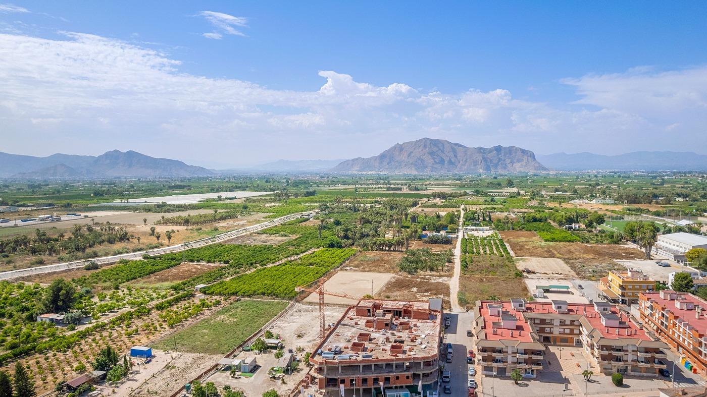 Stunning aerial view of modern new build 3-bedroom apartment in Jacarilla with panoramic open views of lush countryside and mountains.