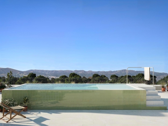 Sun-drenched terrace with sleek infinity pool and panoramic mountain views at a luxury 3-bedroom penthouse in Jacarilla
