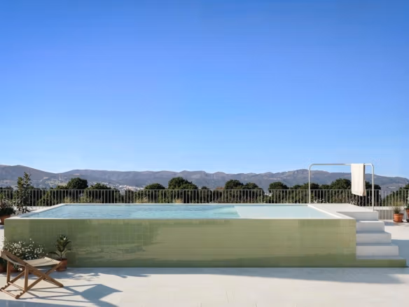 Sun-drenched terrace with sleek infinity pool and panoramic mountain views at a luxury 3-bedroom penthouse in Jacarilla