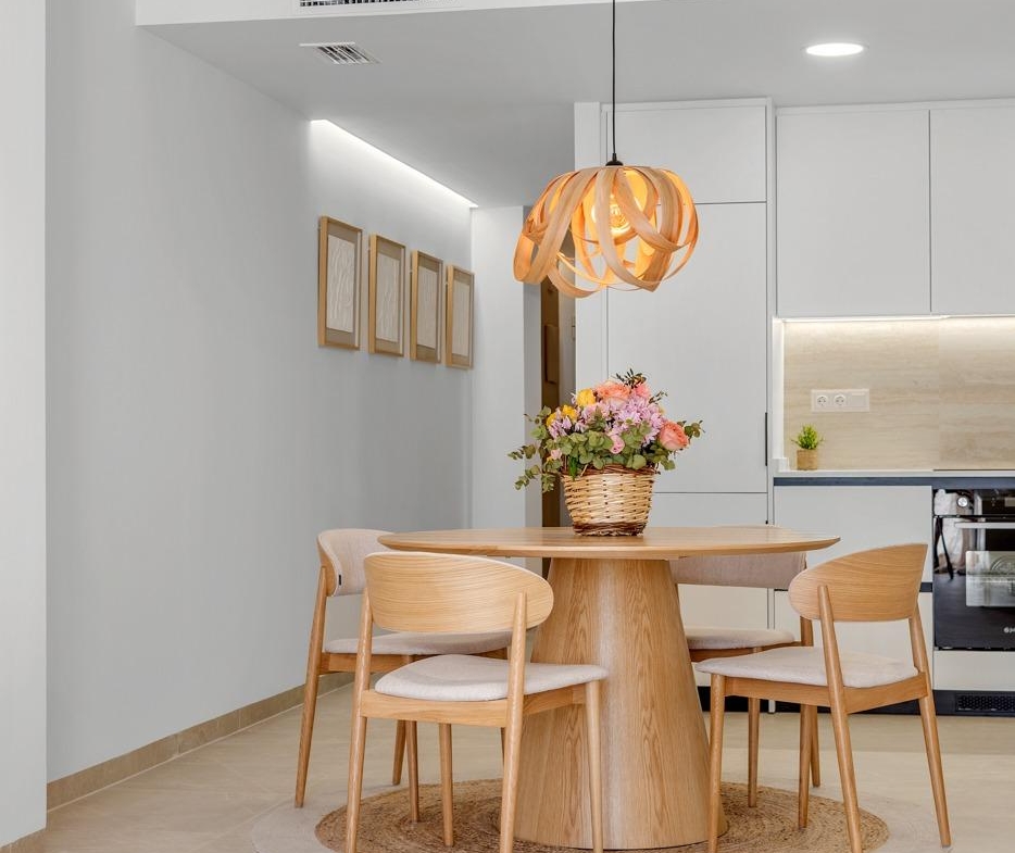 Bright modern dining area with elegant wooden furniture in a new build 3 bedroom penthouse in Jacarilla.