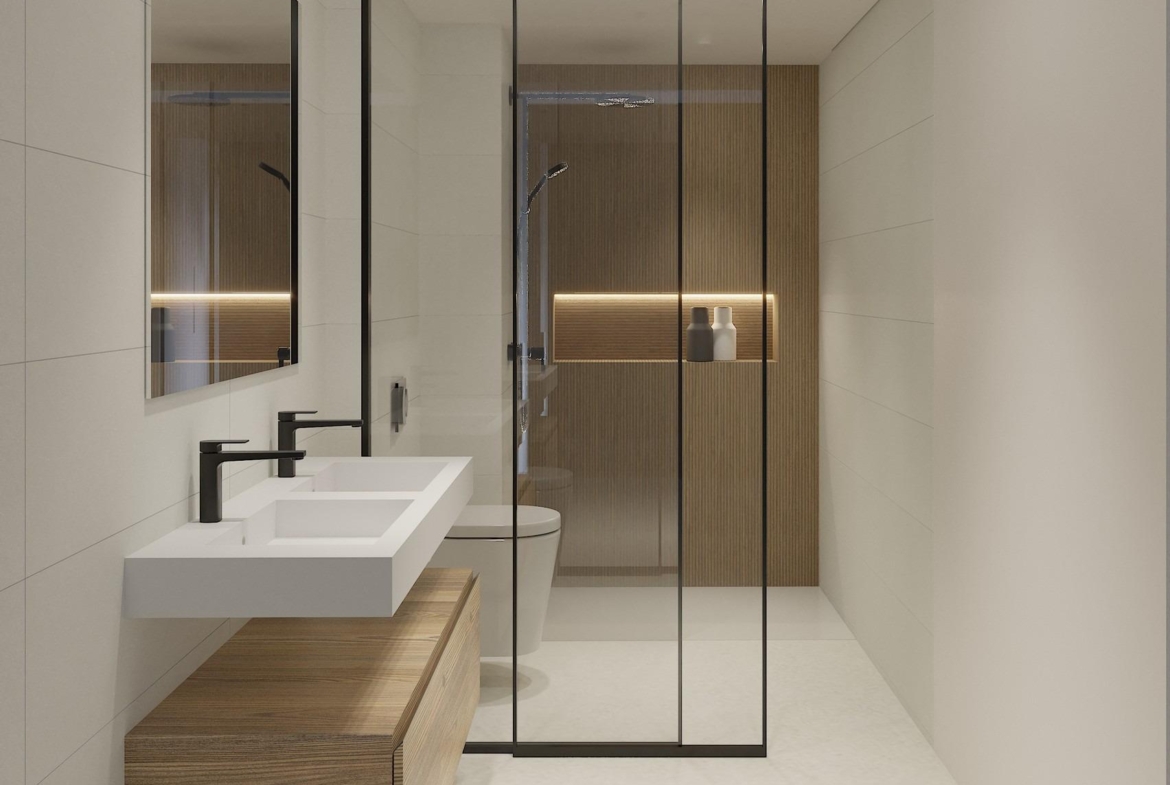 Modern, spacious bathroom with sleek double sink, glass shower enclosure, and warm wood accents in luxury La Mata top floor apartment.