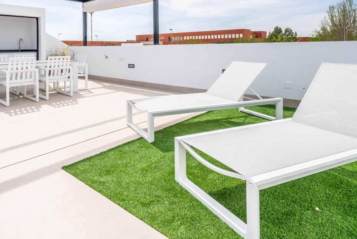 Sun-drenched terrace with sleek white loungers and outdoor dining area at Mediterranean single-storey villa in Roldán, Torre-Pacheco