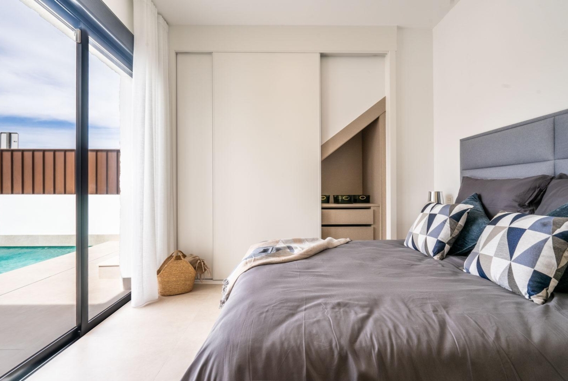 Bright modern bedroom with sliding wardrobe and pool view in Mediterranean single-storey villa in Roldán, Torre-Pacheco.
