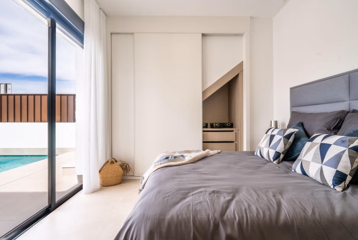 Bright modern bedroom with sliding wardrobe and pool view in Mediterranean single-storey villa in Roldán, Torre-Pacheco.