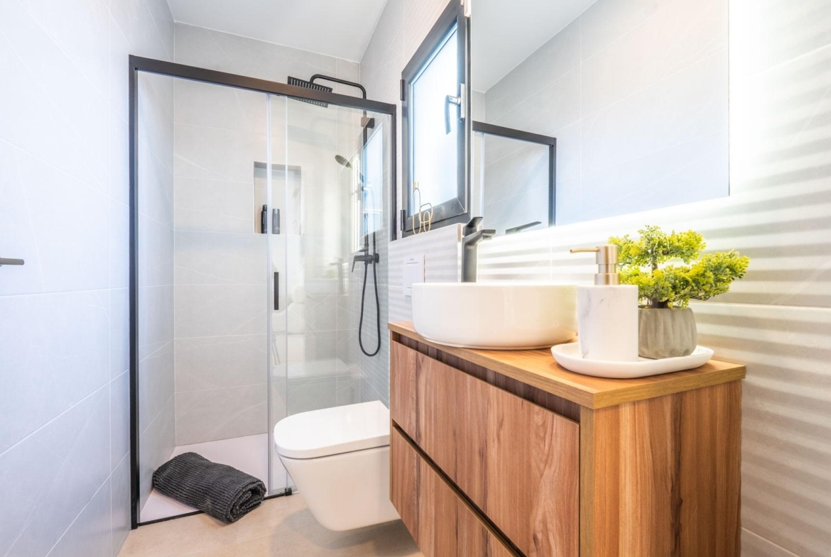 Bright modern bathroom with sleek glass shower and wooden vanity in Mediterranean new build villa, Roldán, Torre-Pacheco.