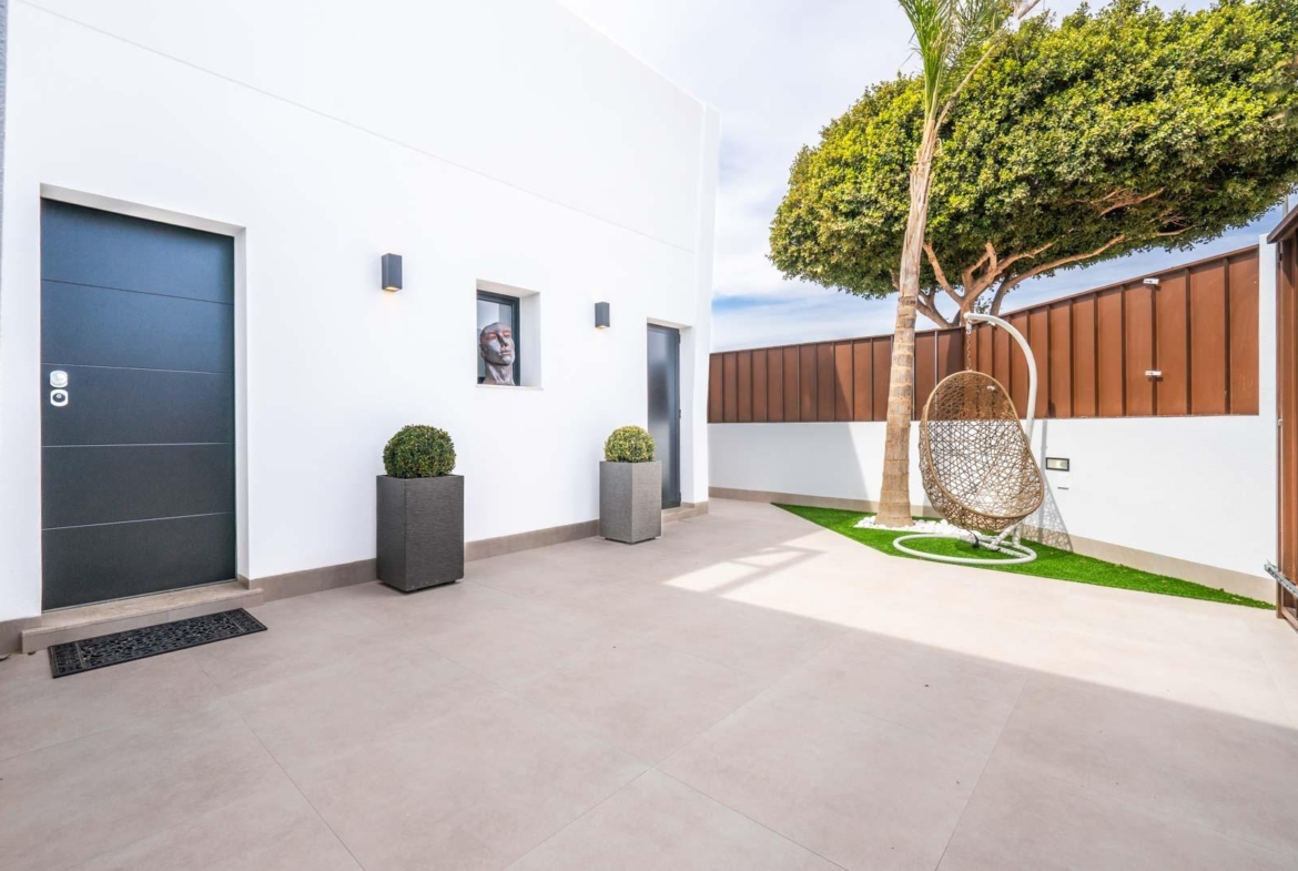 Bright, modern courtyard with stylish hanging chair and minimalist decor in Mediterranean single-storey villa, Roldán, Torre-Pacheco.