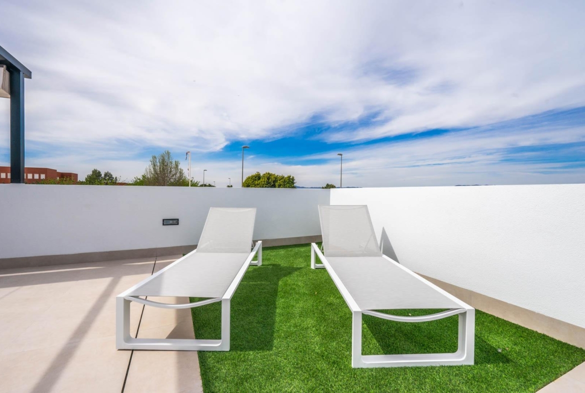 Sun-drenched terrace with modern white loungers and artificial grass in Mediterranean single-storey villa, Roldán, Torre-Pacheco.