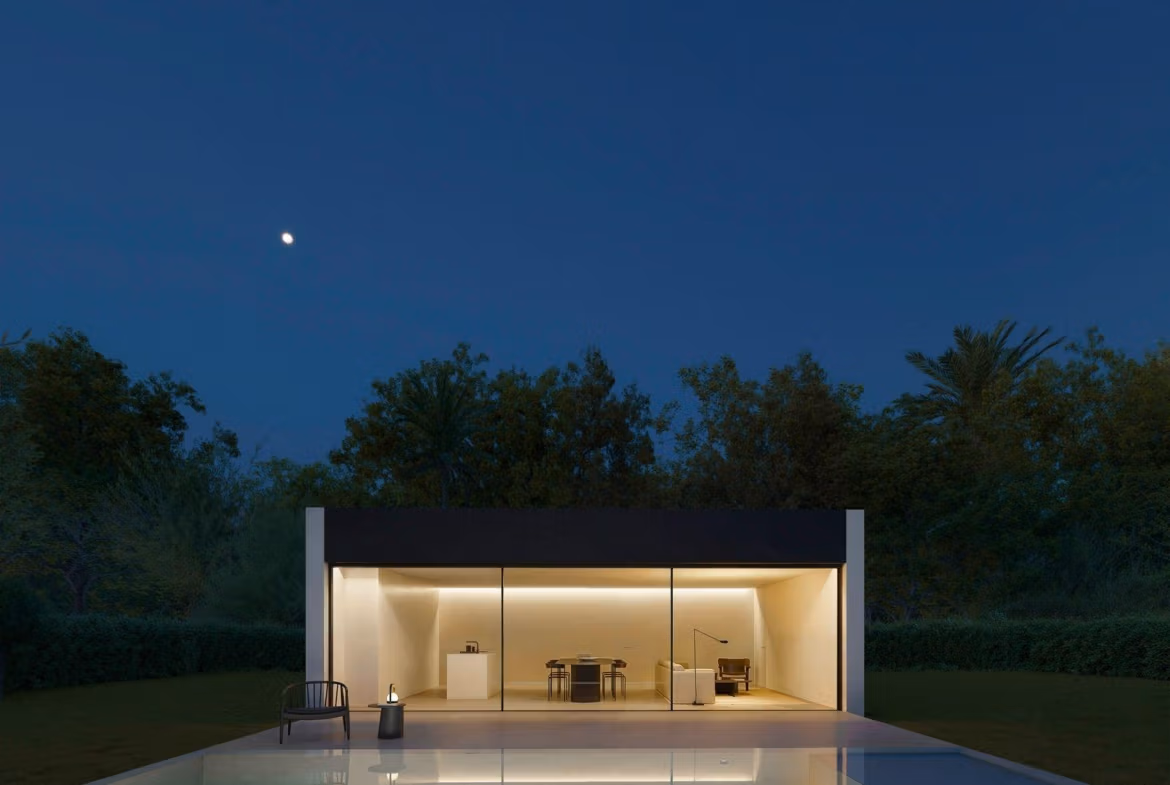 Elegant minimalist single-storey villa in Benidorm with glass-fronted open-plan interior and serene outdoor terrace under twilight sky.