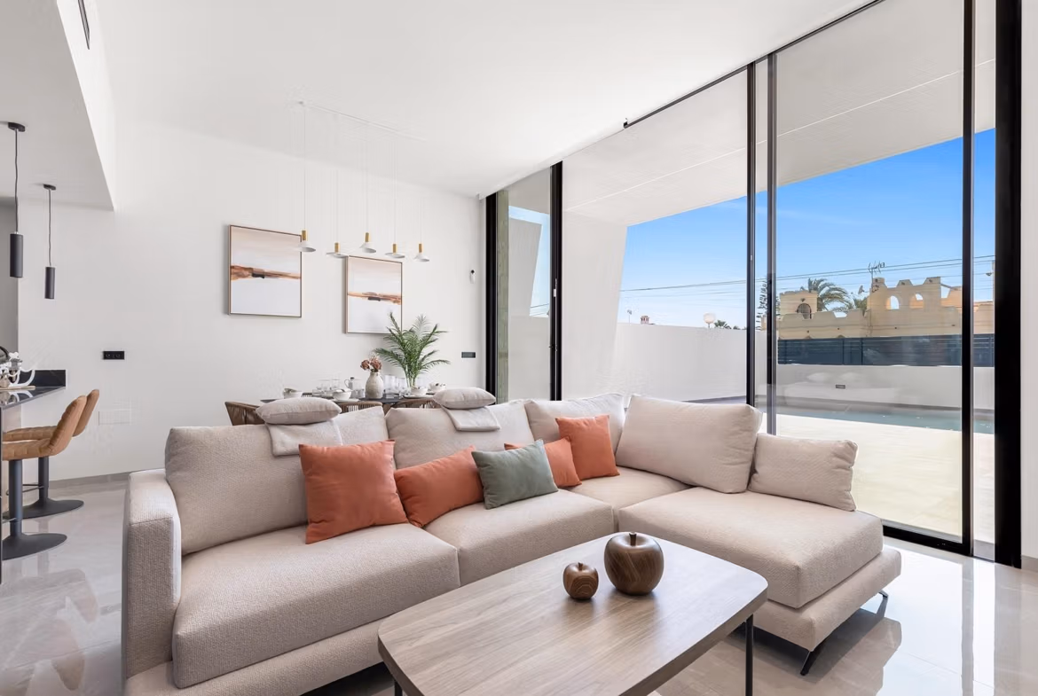 Bright and modern open-plan living area with plush sofa and floor-to-ceiling windows in luxury single-storey villa, Los Balcones, Torrevieja