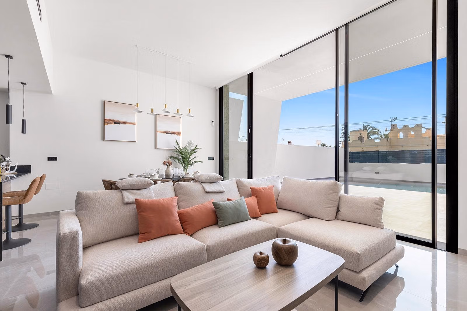New-Build-One-Story-Villas-with-Private-Pool-in-Torrevieja-16 Bright and modern open-plan living area with plush sofa and floor-to-ceiling windows in luxury single-storey villa, Los Balcones, Torrevieja