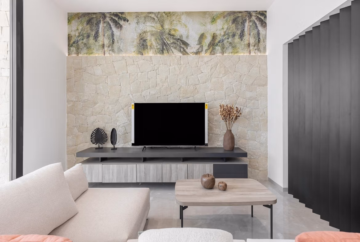Modern, sunlit living room with elegant stone feature wall and sleek furnishings in a key-ready villa in Los Balcones, Torrevieja
