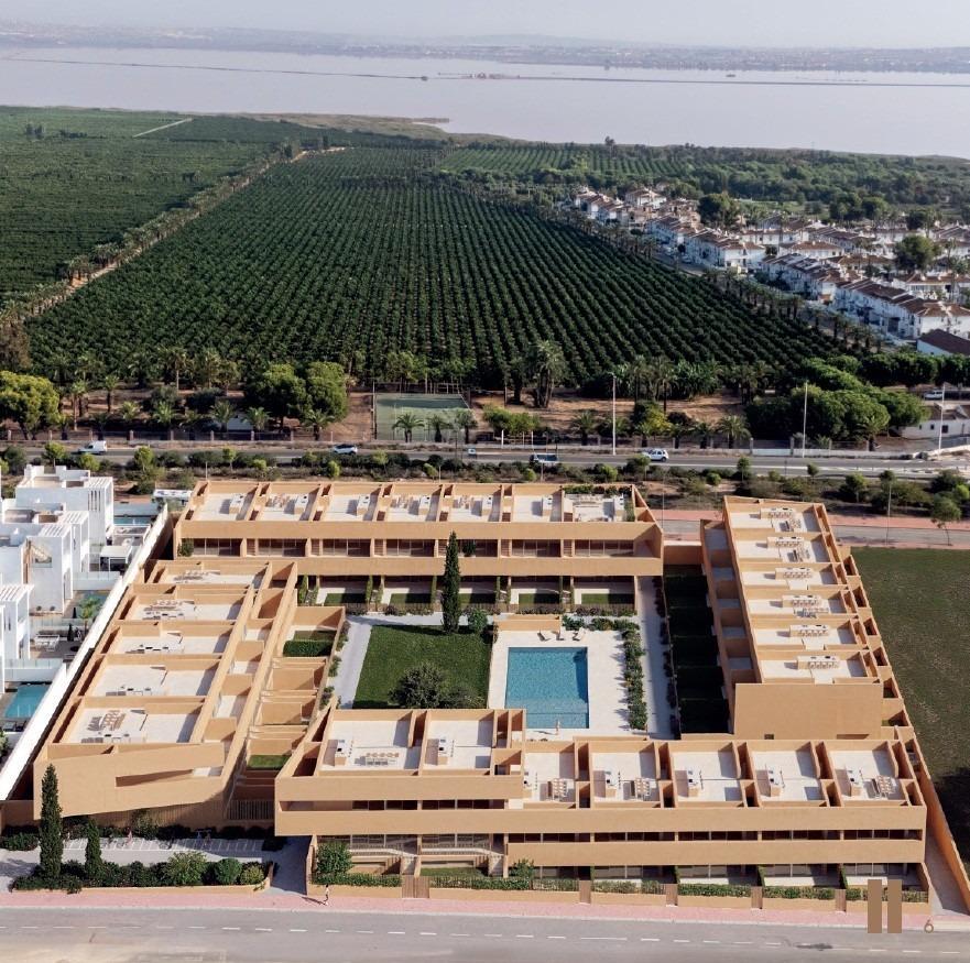 Modern new build residential apartments in Los Balcones, Torrevieja featuring a spacious sunlit courtyard with pool and landscaped gardens.