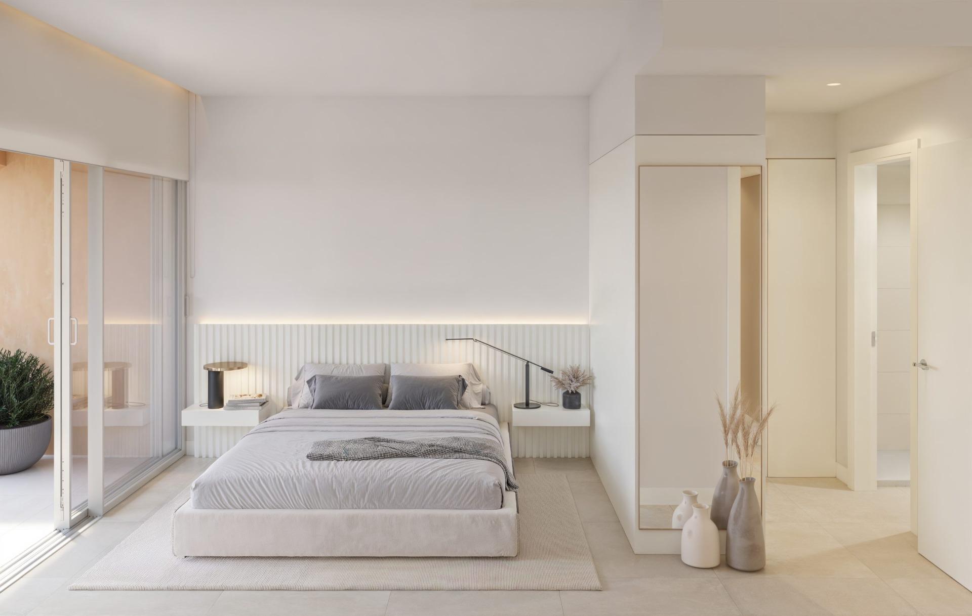 Bright, modern bedroom with minimalist decor and large sliding doors in new build residential apartments in Los Balcones, Torrevieja