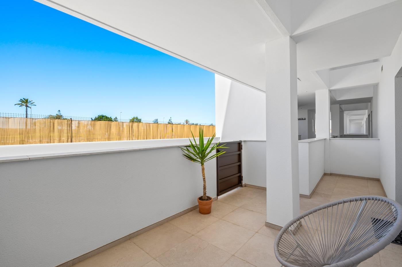Spacious shaded terrace with modern seating and potted plant in a 2-bedroom ground floor apartment with garden in Serena Golf, Los Alcazares
