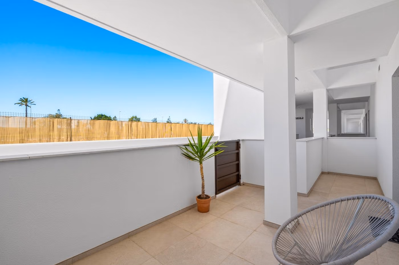 Spacious shaded terrace with modern seating and potted plant in a 2-bedroom ground floor apartment with garden in Serena Golf, Los Alcazares